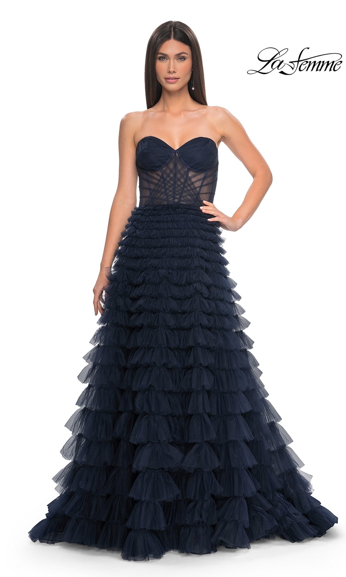 A woman wears the La Femme Strapless Long Ruffled Prom Dress 32283 in dark navy, featuring a fitted bodice and tiered ruffle skirt. The